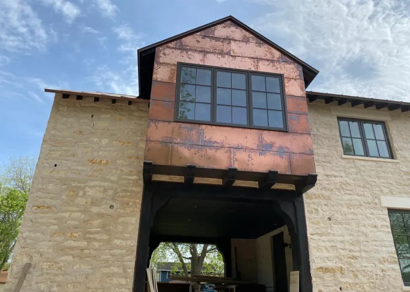 Copper metal panel facade on a stone building for Skylight Installation in East Aurora